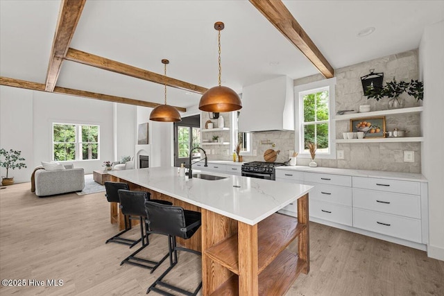 575 E Morganton Rd, Southern Pines, NC 28387 - kitchen with open shelves, custom range hood, beam ceiling, light wood-style floors, and white cabinets
