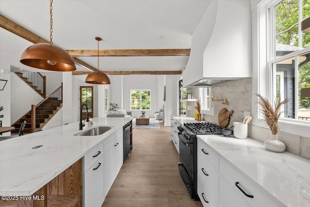 575 E Morganton Rd, Southern Pines, NC 28387 - kitchen with black gas range, custom range hood, dishwasher, beam ceiling, and open floor plan