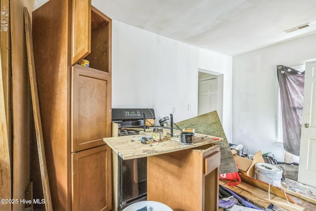 115 Wright St, Wilmington, NC 28401 - kitchen featuring light stone countertops, brown cabinetry, and a peninsula