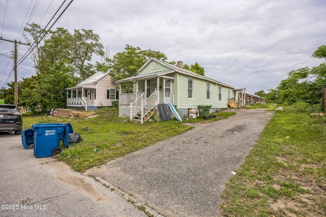 115 Wright St, Wilmington, NC 28401 - view of front of house featuring a chimney, a porch, and driveway