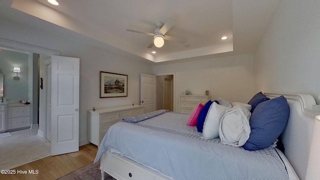 812 Vineyard Dr, New Bern, NC 28562 - bedroom with light wood-type flooring, a tray ceiling, recessed lighting, ensuite bath, and a ceiling fan