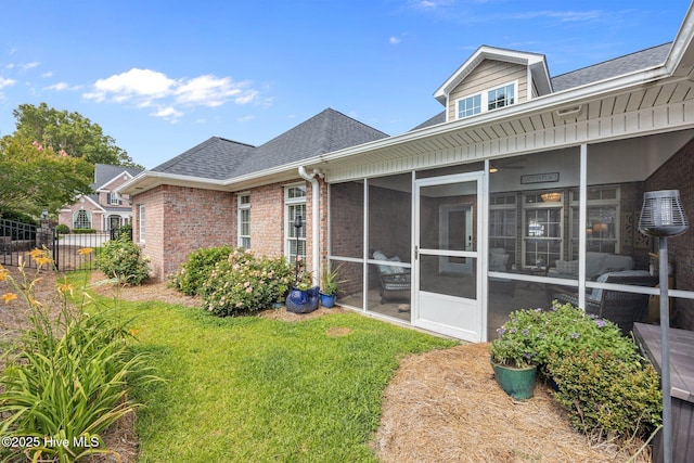812 Vineyard Dr, New Bern, NC 28562 - rear view of property featuring roof with shingles, brick siding, and a sunroom