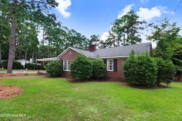 1714 E Walnut St, Goldsboro, NC 27530 - view of side of home featuring brick siding, a lawn, and a chimney