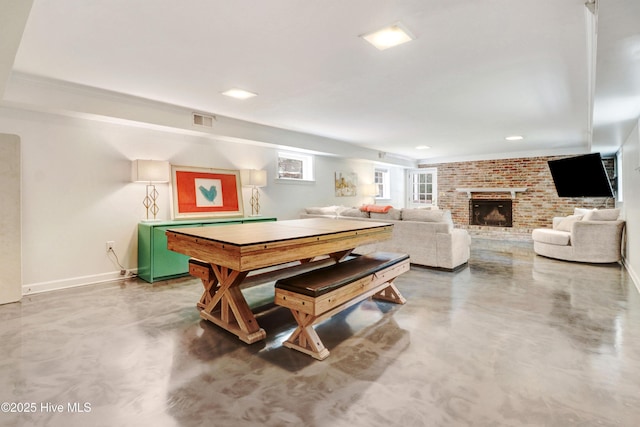 1714 E Walnut St, Goldsboro, NC 27530 - recreation room with finished concrete floors, a fireplace, brick wall, and recessed lighting