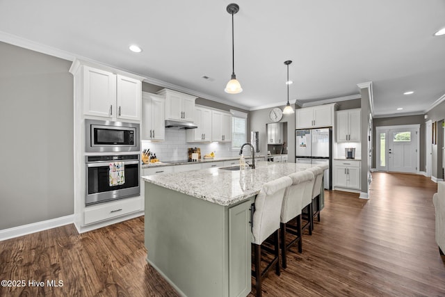 28 Winding Trl, Whispering Pines, NC 28327 - kitchen with stainless steel appliances, crown molding, dark wood-type flooring, decorative backsplash, and under cabinet range hood