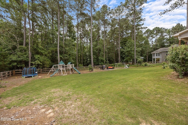 28 Winding Trl, Whispering Pines, NC 28327 - fenced backyard with a playground and a trampoline