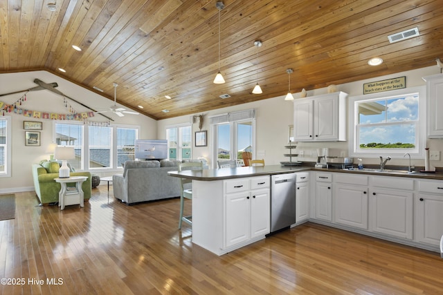 110 Mangrove Blvd, Emerald Isle, NC 28594 - kitchen featuring stainless steel dishwasher, dark countertops, open floor plan, vaulted ceiling, and a peninsula