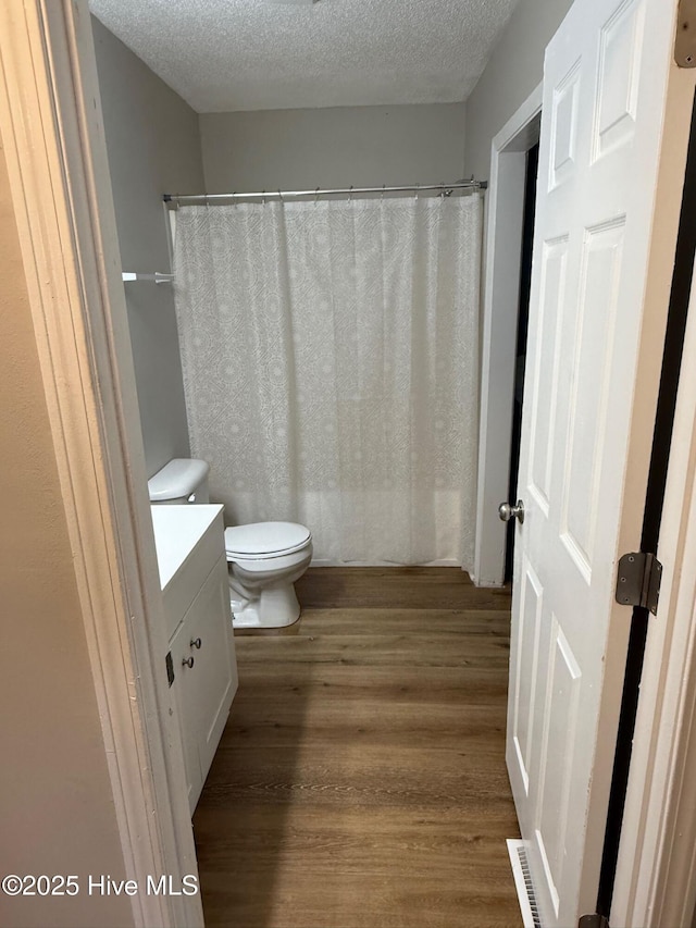 1415 Glenn St, Wilmington, NC 28401 - bathroom featuring wood finished floors, a textured ceiling, vanity, and a shower with shower curtain