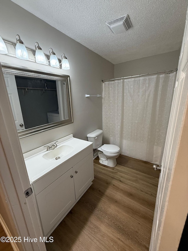 1415 Glenn St, Wilmington, NC 28401 - full bathroom with wood finished floors, vanity, a textured ceiling, and a shower with curtain