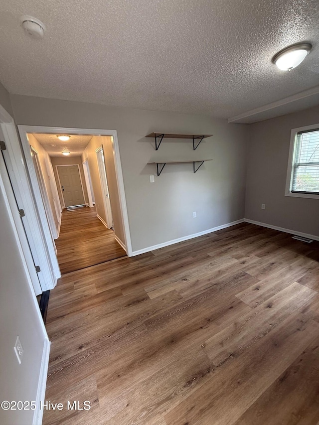 1415 Glenn St, Wilmington, NC 28401 - spare room featuring a textured ceiling, wood finished floors, and a smoke detector