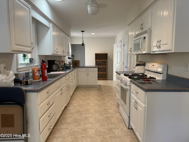 208 Canterwood Ln, New Bern, NC 28562 - kitchen with white appliances, dark countertops, a peninsula, white cabinetry, and a ceiling fan
