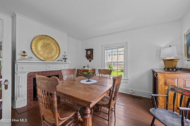 409 Hancock St, New Bern, NC 28560 - dining area featuring hardwood / wood-style flooring, ornamental molding, and a tile fireplace