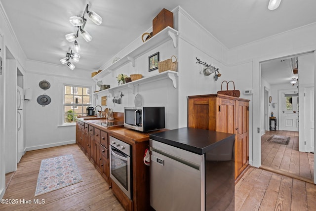 409 Hancock St, New Bern, NC 28560 - kitchen with appliances with stainless steel finishes, open shelves, dark countertops, light wood-style flooring, and ornamental molding