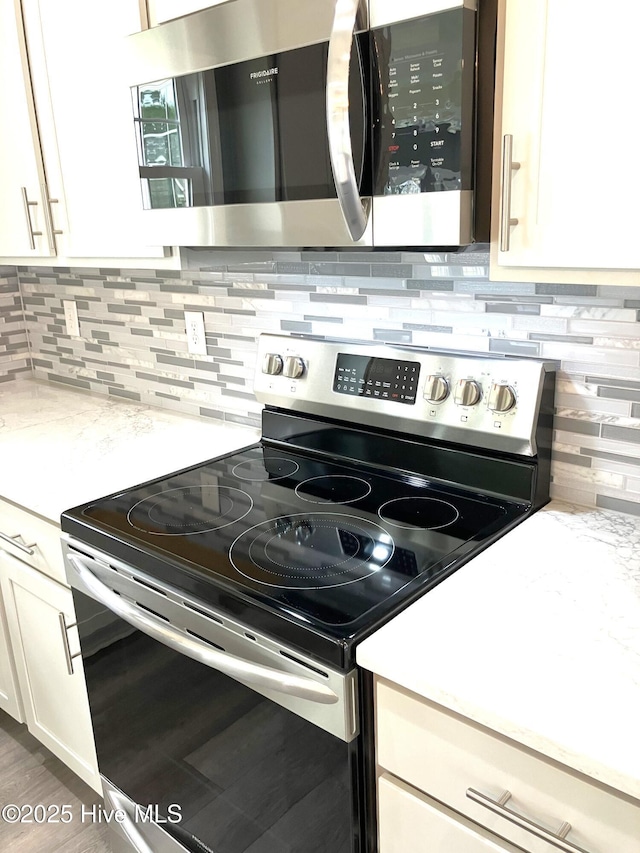 407 King Richard Ct, Jacksonville, NC 28546 - kitchen featuring appliances with stainless steel finishes, white cabinetry, and decorative backsplash