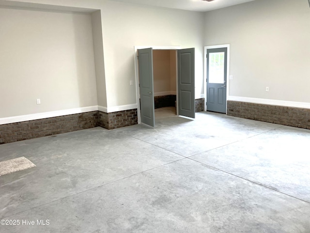 407 King Richard Ct, Jacksonville, NC 28546 - unfurnished bedroom featuring brick wall and concrete flooring