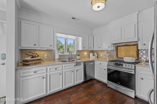 938 E Bayside Dr, Chocowinity, NC 27817 - kitchen with appliances with stainless steel finishes, white cabinets, dark wood finished floors, tasteful backsplash, and light stone counters