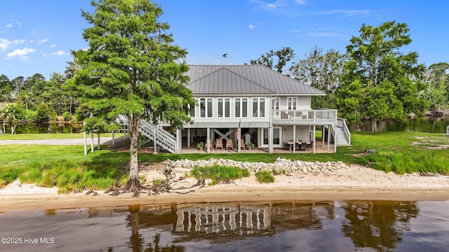 938 E Bayside Dr, Chocowinity, NC 27817 - rear view of house with stairs, a deck with water view, a metal roof, a lawn, and a standing seam roof