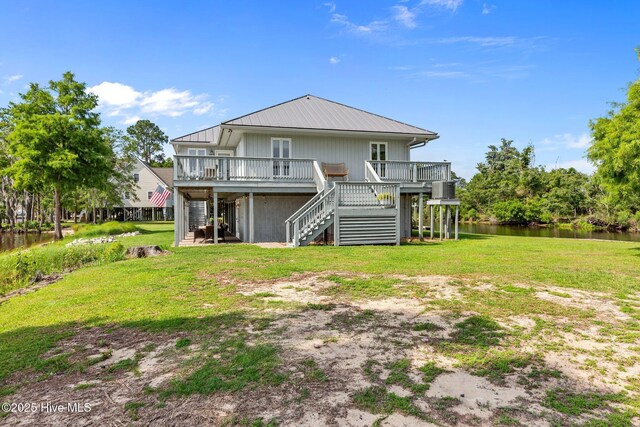 938 E Bayside Dr, Chocowinity, NC 27817 - rear view of house with stairs, a deck with water view, a lawn, and a metal roof