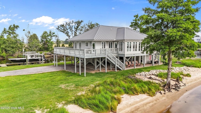 938 E Bayside Dr, Chocowinity, NC 27817 - view of front of house with stairway, a metal roof, a front yard, gravel driveway, and a water view