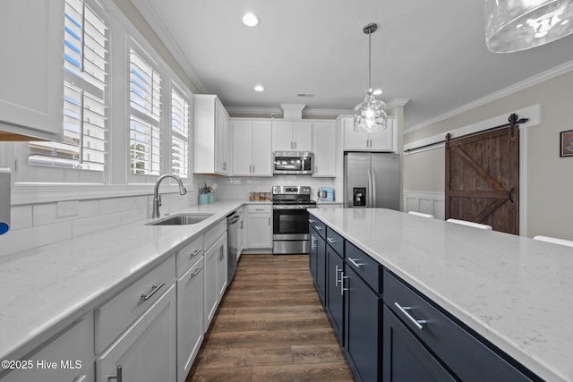 184 Twining Rose Ln, Holly Ridge, NC 28445 - kitchen featuring appliances with stainless steel finishes, white cabinetry, ornamental molding, a barn door, and decorative backsplash