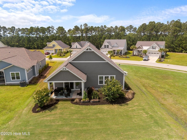 184 Twining Rose Ln, Holly Ridge, NC 28445 - rear view of house with a yard, a residential view, a garage, and view of wooded area