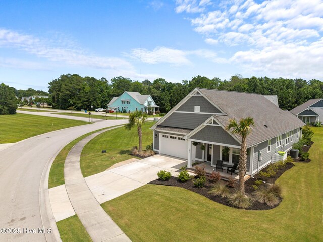 184 Twining Rose Ln, Holly Ridge, NC 28445 - view of front of house featuring concrete driveway, a front yard, a garage, a porch, and view of wooded area