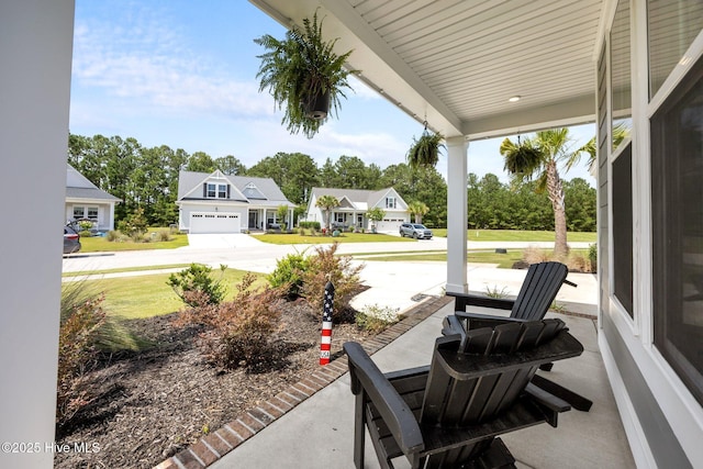184 Twining Rose Ln, Holly Ridge, NC 28445 - covered porch featuring concrete driveway, a residential view, and a garage