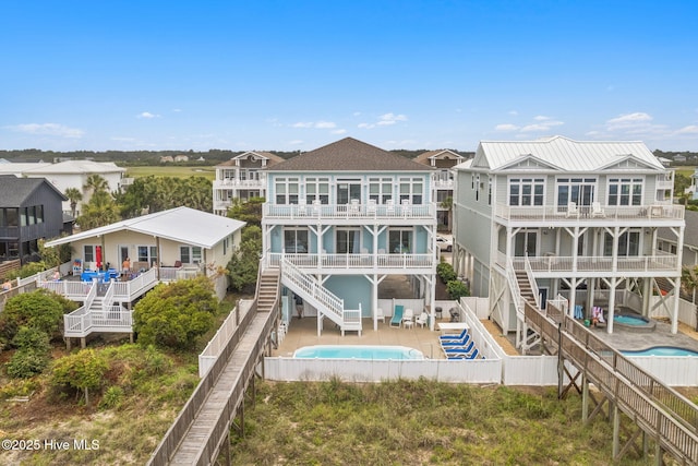 328 E First St, Ocean Isle Beach, NC 28469 - back of house with a fenced backyard, stairway, and a balcony