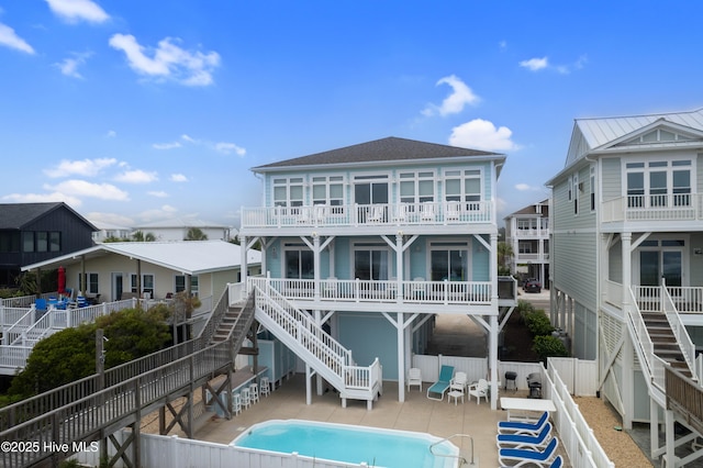 328 E First St, Ocean Isle Beach, NC 28469 - rear view of property with stairway, a shingled roof, a fenced backyard, and a patio
