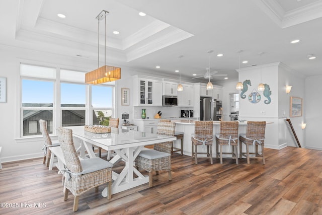 328 E First St, Ocean Isle Beach, NC 28469 - dining room featuring recessed lighting, wood finished floors, ornamental molding, a raised ceiling, and a ceiling fan