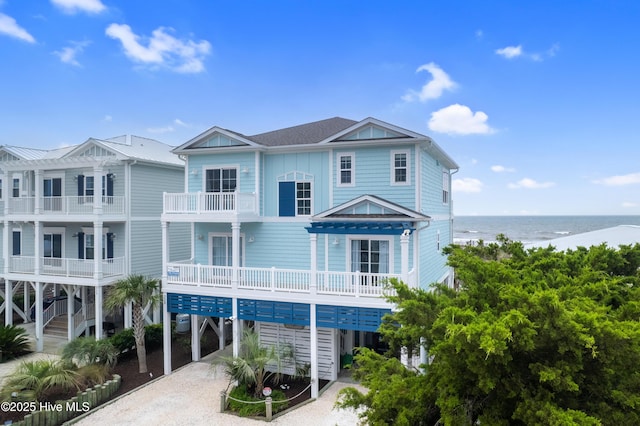 328 E First St, Ocean Isle Beach, NC 28469 - view of front of house with a carport, a water view, dirt driveway, and board and batten siding