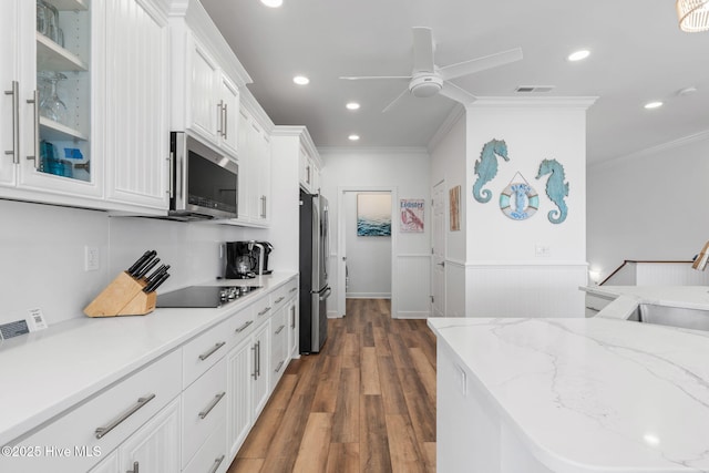 328 E First St, Ocean Isle Beach, NC 28469 - kitchen with stainless steel appliances, a ceiling fan, ornamental molding, white cabinetry, and wood finished floors