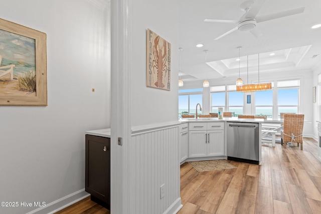 328 E First St, Ocean Isle Beach, NC 28469 - kitchen with stainless steel dishwasher, a peninsula, light wood finished floors, light countertops, and hanging light fixtures