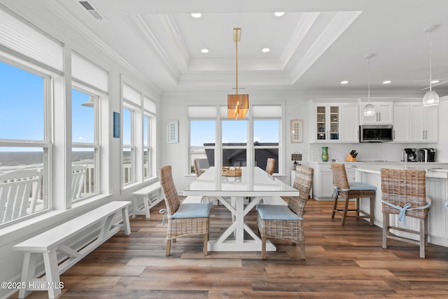 328 E First St, Ocean Isle Beach, NC 28469 - dining room featuring dark wood finished floors, a raised ceiling, ornamental molding, and recessed lighting