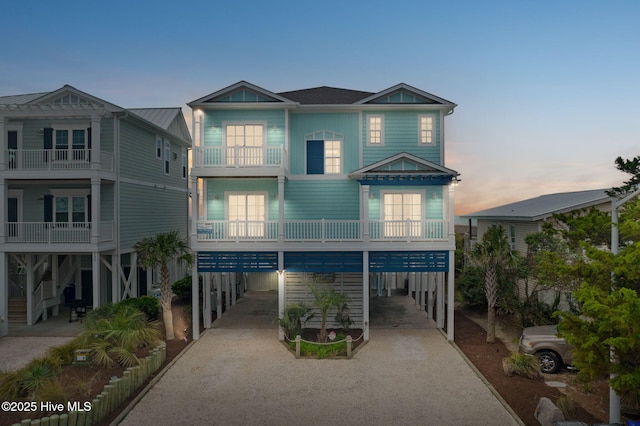 328 E First St, Ocean Isle Beach, NC 28469 - coastal inspired home featuring a carport, driveway, and a balcony