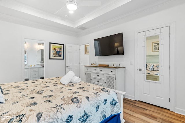328 E First St, Ocean Isle Beach, NC 28469 - bedroom featuring ornamental molding, wood finished floors, a raised ceiling, ensuite bathroom, and a ceiling fan