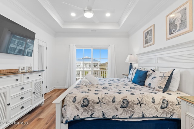328 E First St, Ocean Isle Beach, NC 28469 - bedroom with wood finished floors, a raised ceiling, ornamental molding, ceiling fan, and recessed lighting