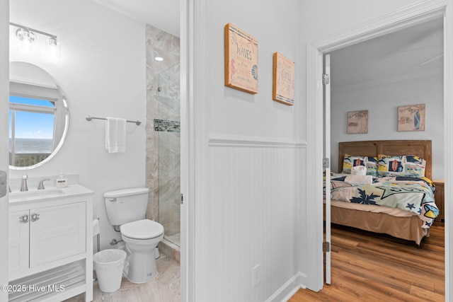 328 E First St, Ocean Isle Beach, NC 28469 - full bathroom with vanity, a stall shower, a wainscoted wall, ensuite bathroom, and wood finished floors