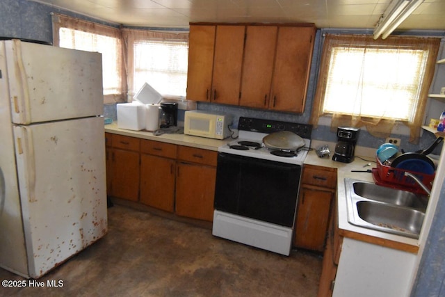 404 N Third St, Carolina Beach, NC 28428 - kitchen featuring white appliances, plenty of natural light, light countertops, and brown cabinets
