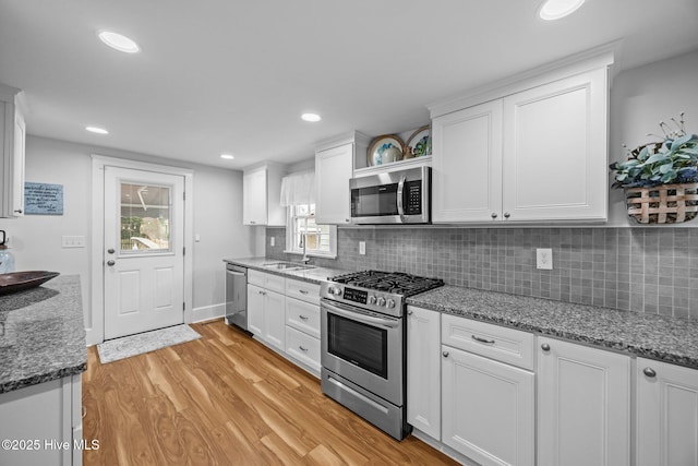 209 E Main St, Washington, NC 27889 - kitchen featuring stainless steel appliances, white cabinets, light wood finished floors, tasteful backsplash, and recessed lighting