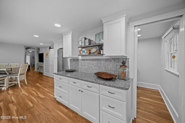 209 E Main St, Washington, NC 27889 - kitchen featuring backsplash, light wood-style floors, white cabinetry, light stone counters, and recessed lighting