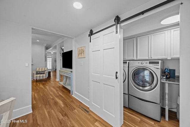 209 E Main St, Washington, NC 27889 - laundry room with cabinet space, light wood-style floors, a barn door, and recessed lighting