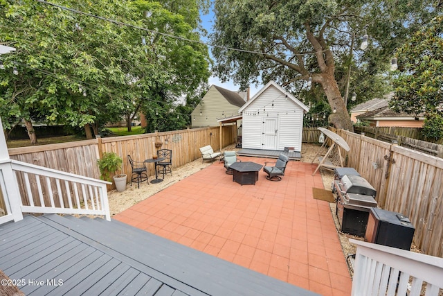 209 E Main St, Washington, NC 27889 - fenced backyard with an outdoor fire pit, a deck, a storage unit, and a patio