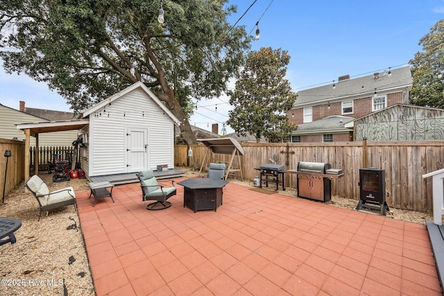 209 E Main St, Washington, NC 27889 - fenced backyard featuring an outdoor fire pit, a patio, a grill, and a storage shed