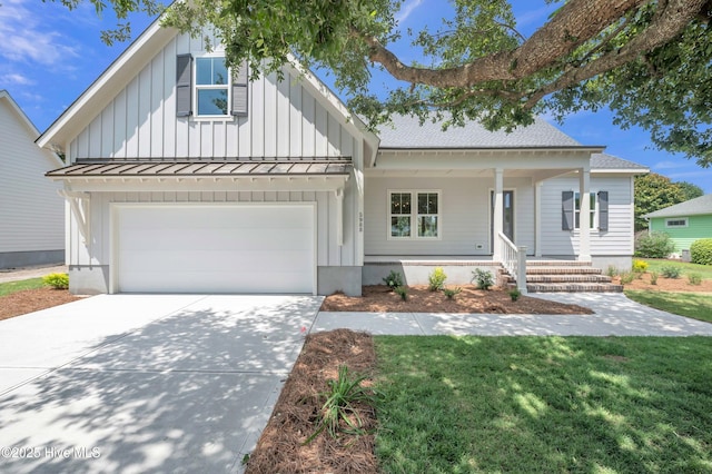 5988 Gray Squirrel Path, Southport, NC 28461 - view of front of home with a standing seam roof, board and batten siding, concrete driveway, and covered porch