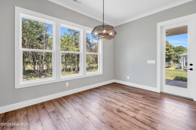 5988 Gray Squirrel Path, Southport, NC 28461 - unfurnished dining area with a chandelier, ornamental molding, and wood finished floors