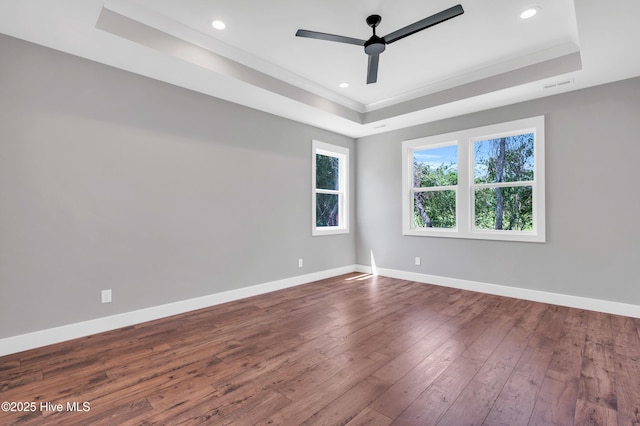 5988 Gray Squirrel Path, Southport, NC 28461 - unfurnished room with a tray ceiling, a ceiling fan, dark wood-style flooring, recessed lighting, and ornamental molding
