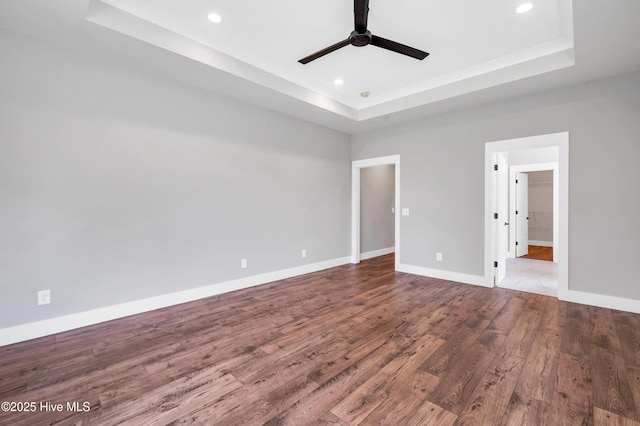 5988 Gray Squirrel Path, Southport, NC 28461 - unfurnished bedroom featuring a tray ceiling, wood finished floors, recessed lighting, and a ceiling fan