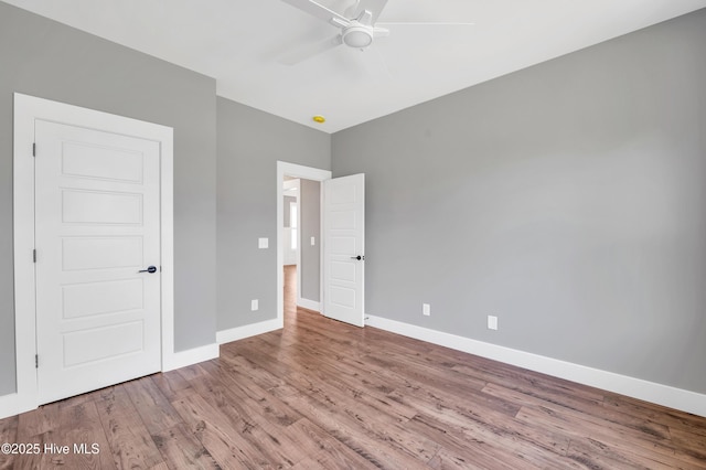 5988 Gray Squirrel Path, Southport, NC 28461 - unfurnished bedroom with wood finished floors and ceiling fan