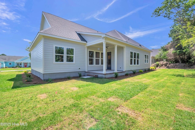 5988 Gray Squirrel Path, Southport, NC 28461 - rear view of property featuring a ceiling fan, a lawn, roof with shingles, and a patio